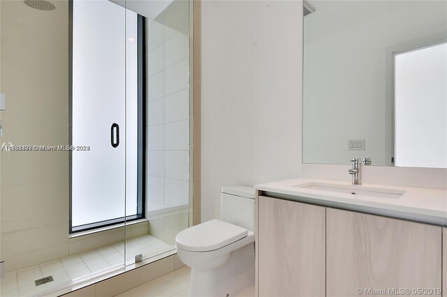 bathroom with vanity, toilet, and a shower with door