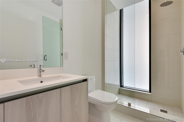 bathroom featuring tile flooring, tiled shower, toilet, and vanity