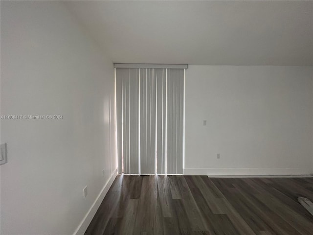 unfurnished room with dark wood-type flooring