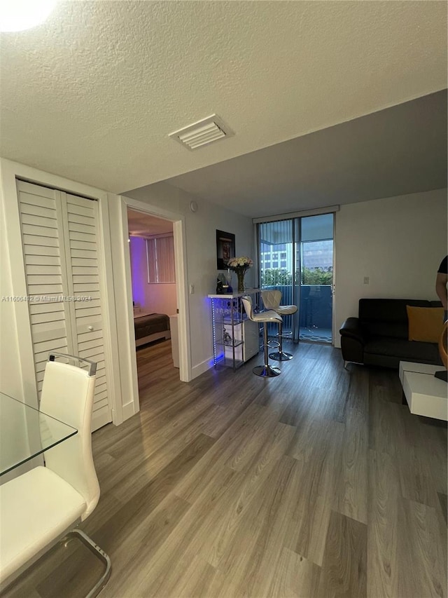 office area with a wall of windows, hardwood / wood-style floors, and a textured ceiling