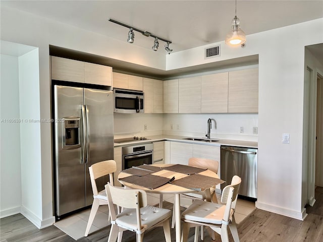 4250 Biscayne Blvd Unit 806, Miami, FL 33137 - kitchen with track lighting, appliances with stainless steel finishes, a sink, and light wood-type flooring