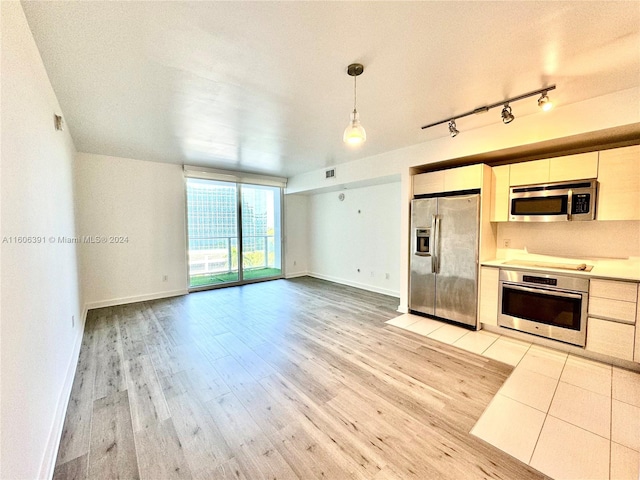 kitchen with white cabinetry, a textured ceiling, light wood-type flooring, pendant lighting, and stainless steel appliances