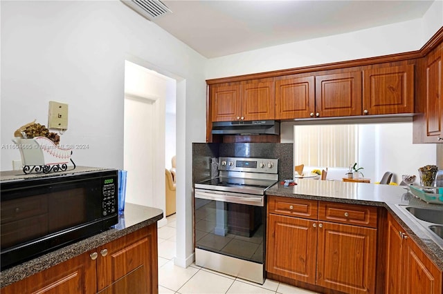 kitchen featuring stainless steel range with electric stovetop, dark stone counters, and light tile floors