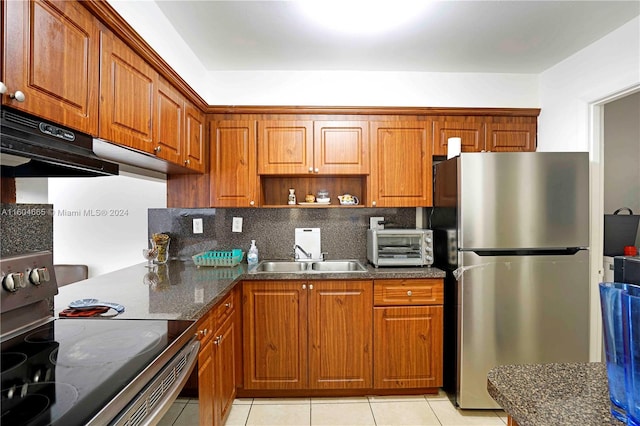 kitchen featuring stainless steel appliances, tasteful backsplash, fume extractor, sink, and light tile floors