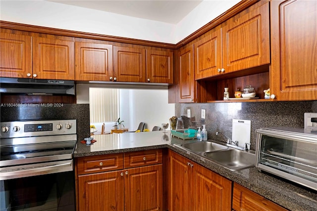 kitchen with sink, stainless steel electric stove, backsplash, and dark stone counters