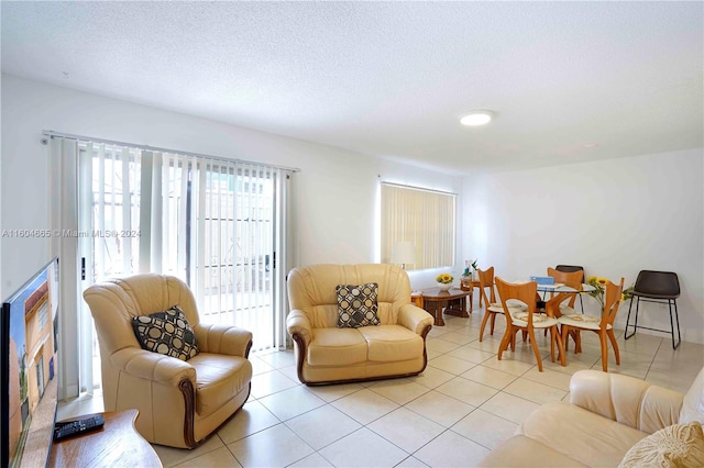 living room with a textured ceiling and light tile floors