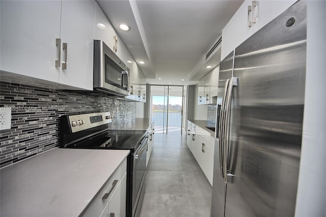 kitchen featuring appliances with stainless steel finishes, white cabinetry, tasteful backsplash, and light tile floors