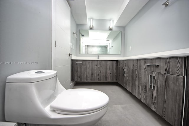 bathroom featuring concrete floors, toilet, and vanity with extensive cabinet space