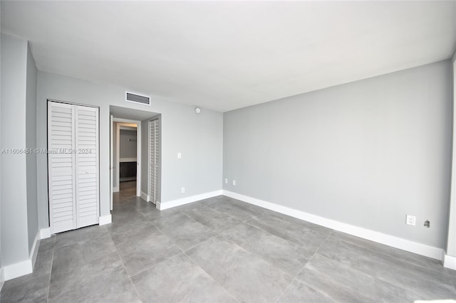 unfurnished bedroom with tile flooring and a closet