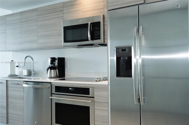 kitchen featuring sink, stainless steel appliances, and light brown cabinetry