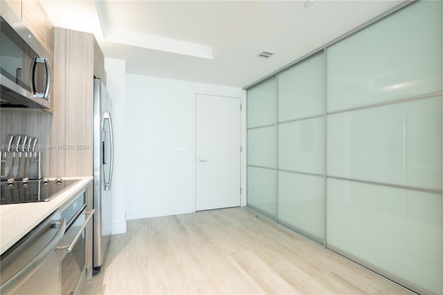 kitchen featuring light wood-type flooring and appliances with stainless steel finishes