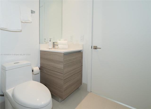 bathroom featuring tile patterned flooring, vanity, and toilet