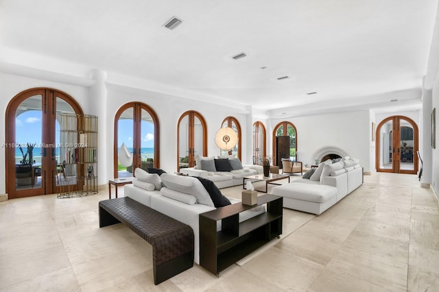 living room featuring a healthy amount of sunlight, french doors, and light tile flooring