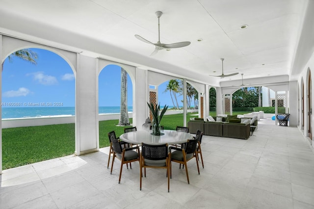 sunroom with a water view and ceiling fan