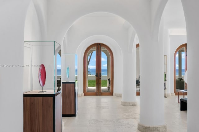 tiled entrance foyer with a water view and french doors