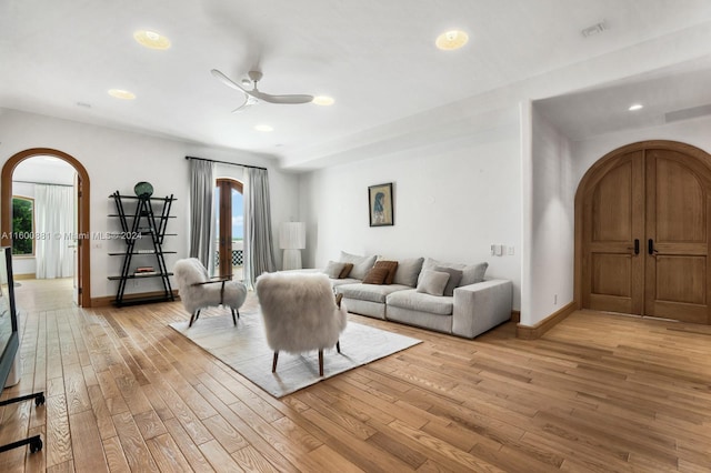 living room with ceiling fan and light hardwood / wood-style flooring