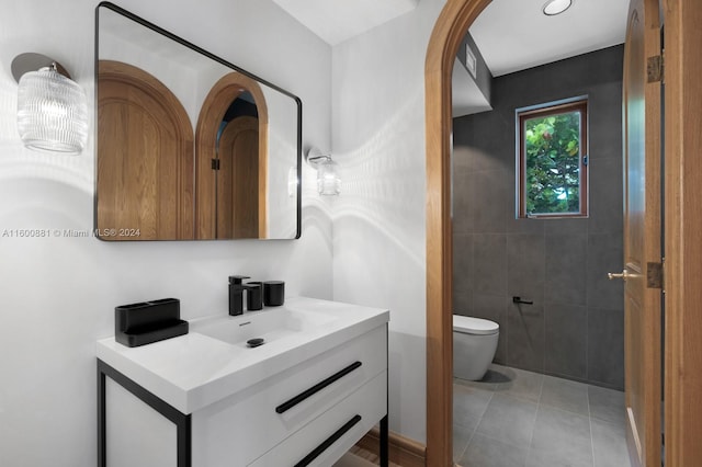 bathroom featuring tile walls, tile floors, vanity, and toilet