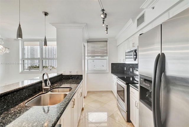 kitchen with hanging light fixtures, stainless steel appliances, dark stone counters, and sink