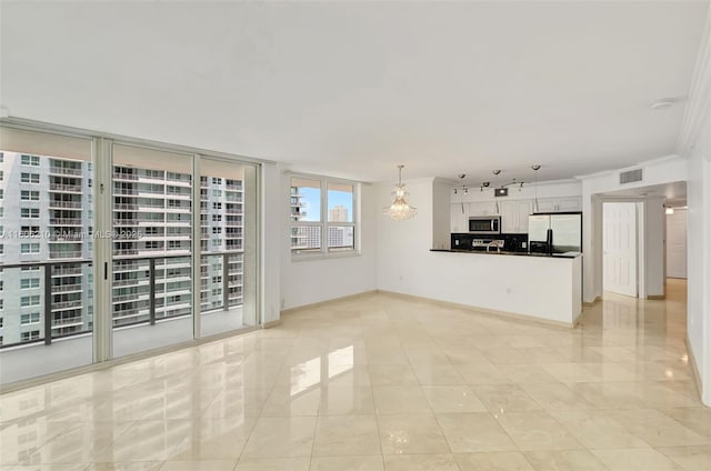 unfurnished living room with crown molding and expansive windows