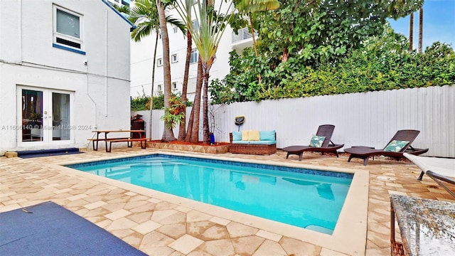 view of swimming pool featuring a patio and french doors