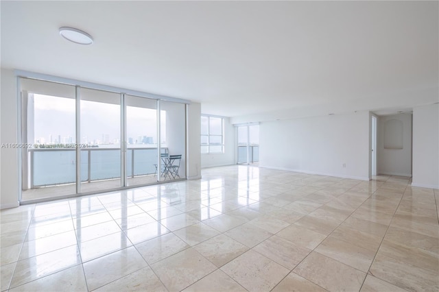 unfurnished room featuring a wall of windows