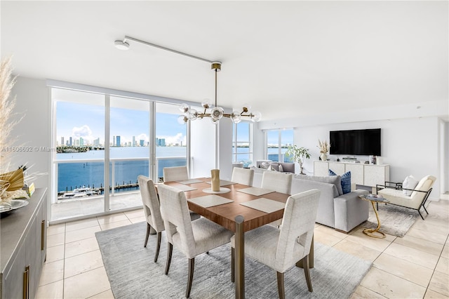 tiled dining space featuring a chandelier and a water view