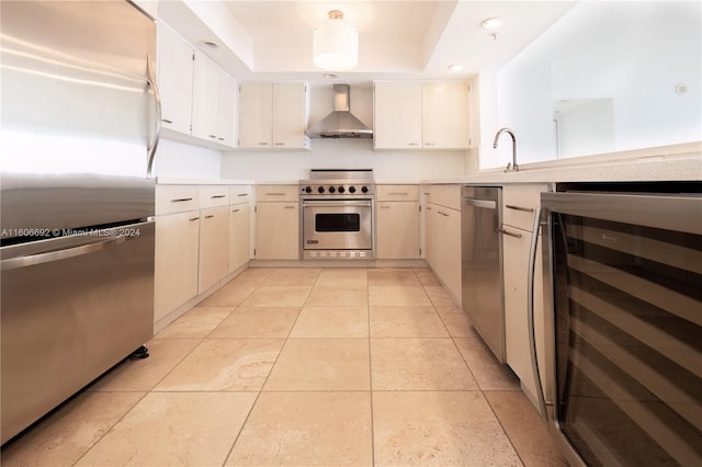 kitchen featuring wall chimney exhaust hood, stainless steel appliances, sink, wine cooler, and light tile patterned flooring