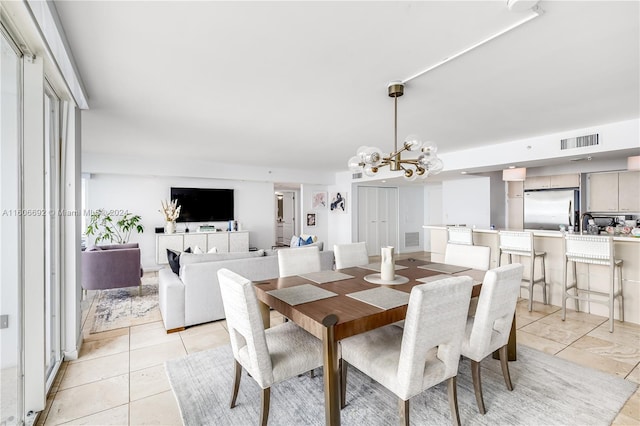 dining area featuring light tile patterned flooring and a notable chandelier