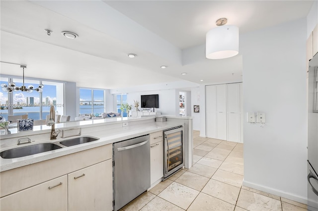 kitchen with dishwasher, sink, beverage cooler, decorative light fixtures, and a water view