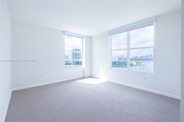 carpeted spare room featuring a water view