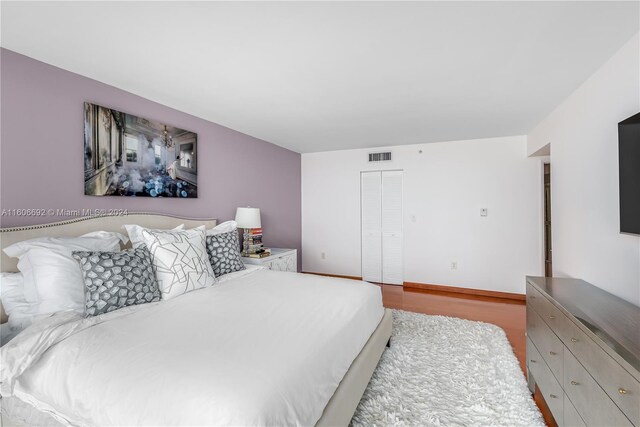 bedroom with light hardwood / wood-style floors and a closet