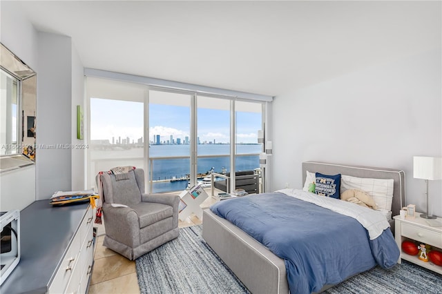 tiled bedroom featuring floor to ceiling windows and a water view