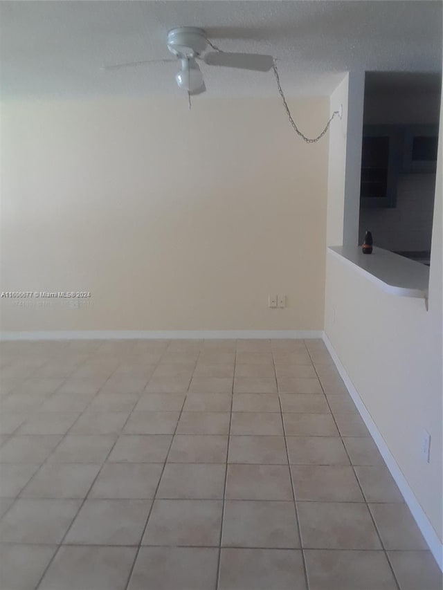 unfurnished room with ceiling fan and light tile patterned floors