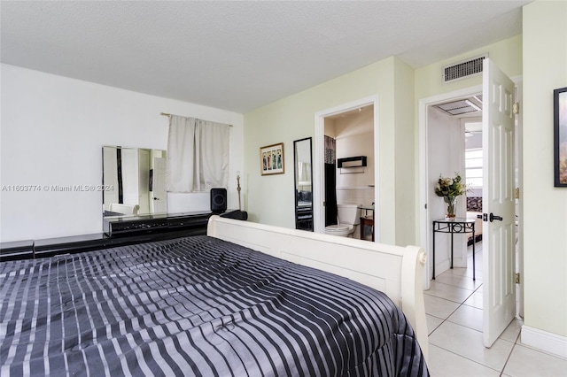 bedroom with a textured ceiling and light tile patterned flooring