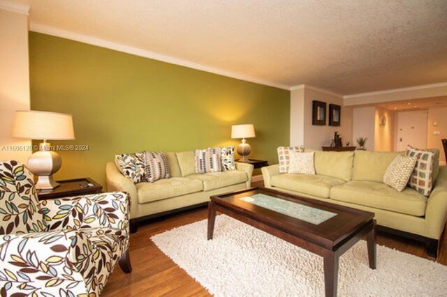 living room with dark hardwood / wood-style flooring and ornamental molding