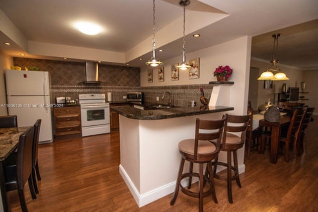 kitchen featuring white fridge, dark hardwood / wood-style floors, tasteful backsplash, range, and sink