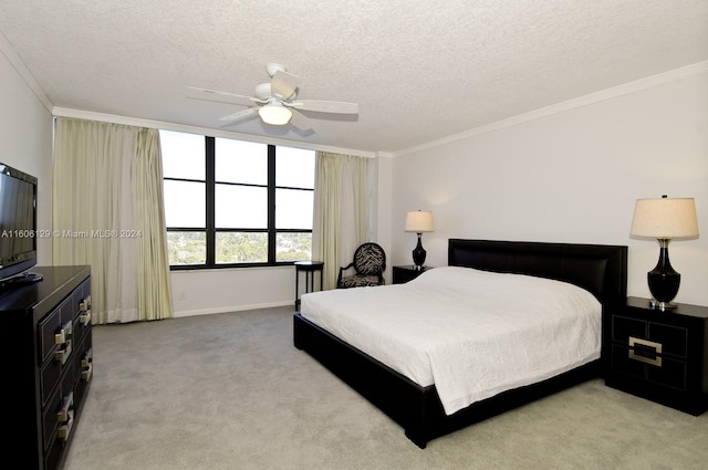 bedroom featuring ceiling fan, ornamental molding, a textured ceiling, and light carpet