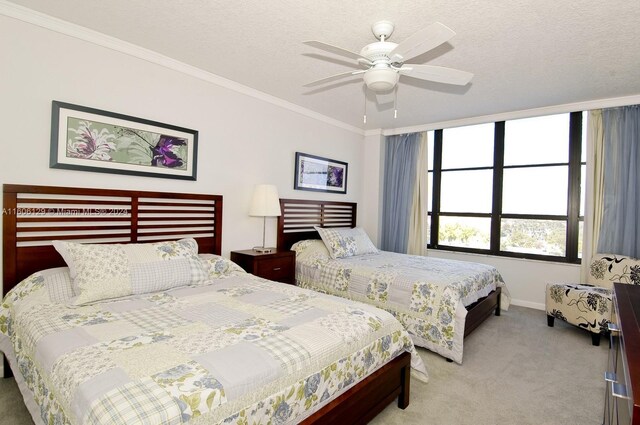 bedroom featuring ceiling fan, carpet floors, a textured ceiling, and ornamental molding