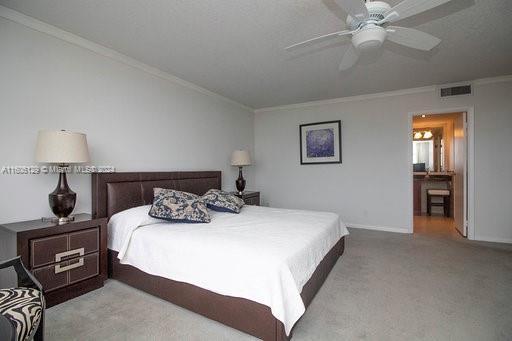 carpeted bedroom with ceiling fan and crown molding