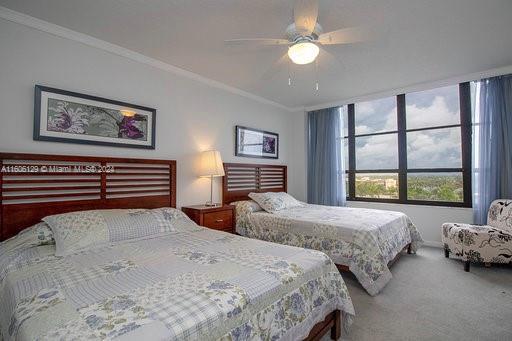 bedroom with ceiling fan, crown molding, and carpet flooring