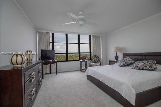 bedroom with ceiling fan, crown molding, and light carpet