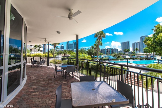 balcony with a community pool and ceiling fan