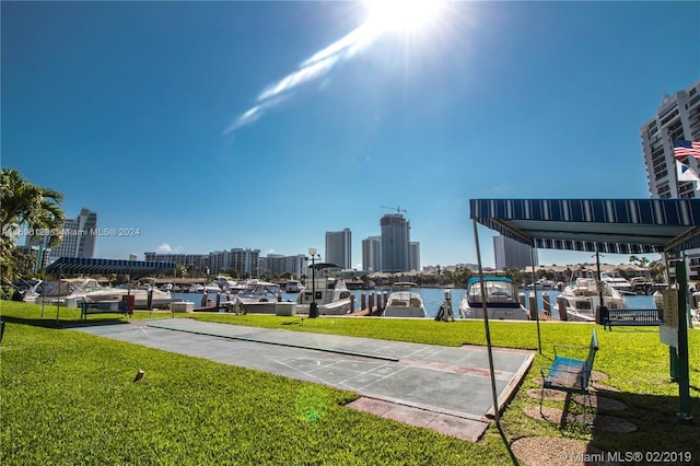 view of property's community with a water view and a lawn