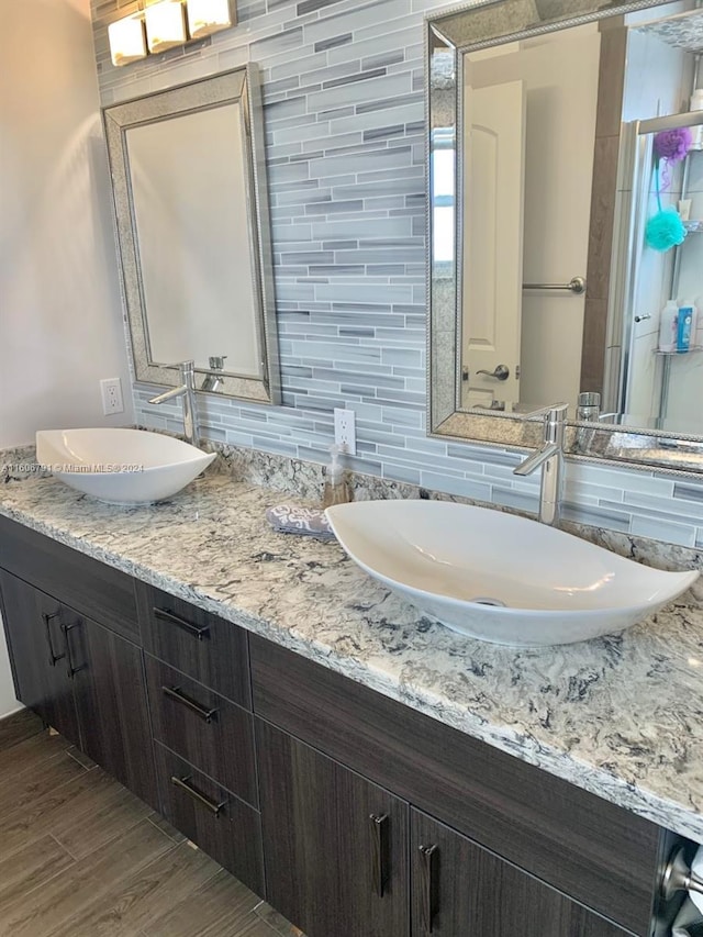 bathroom with tile walls, dual vanity, and backsplash