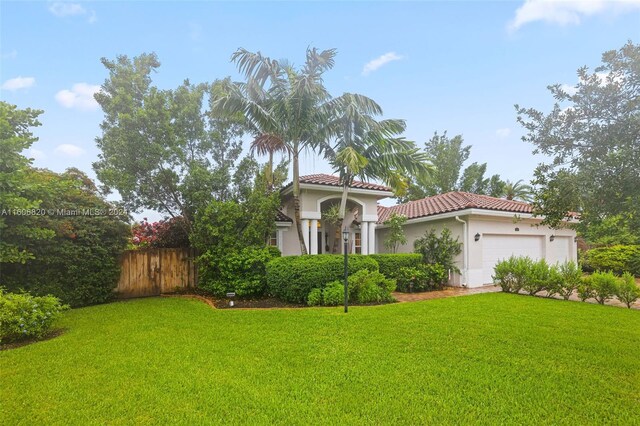 mediterranean / spanish-style house featuring a front yard and a garage