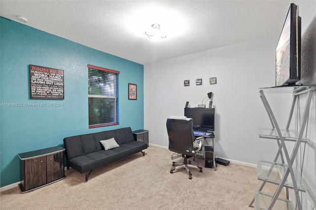 carpeted home office featuring a textured ceiling