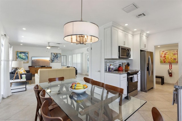 tiled dining space with ceiling fan and a wealth of natural light