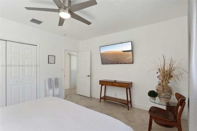 tiled bedroom featuring ceiling fan and a closet