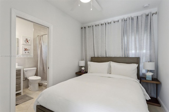 bedroom with ceiling fan, light tile patterned flooring, and ensuite bath