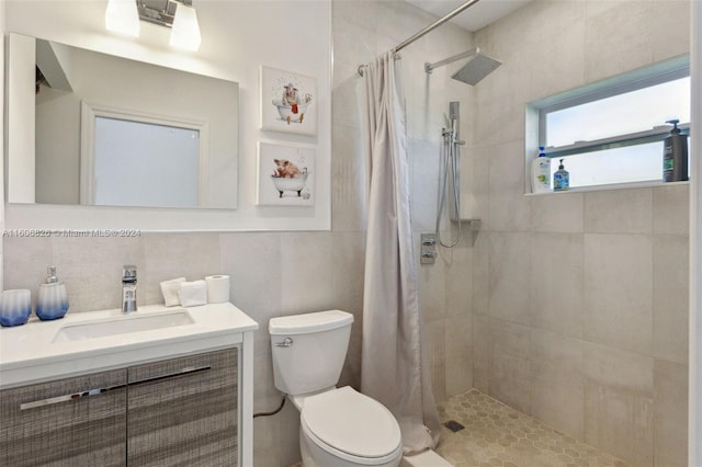 bathroom with a shower with shower curtain, tile walls, tasteful backsplash, toilet, and vanity